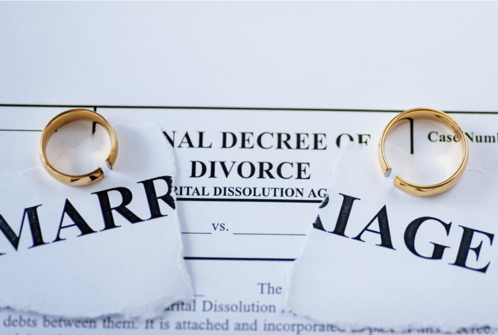 two wedding rings resting on a certificate of divorce