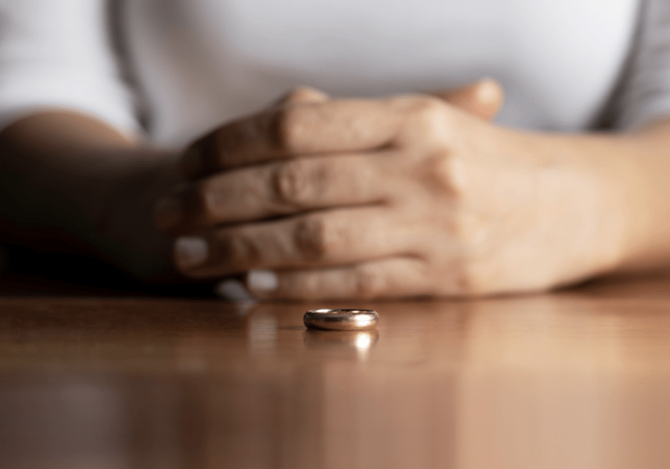 Someone with their wedding ring resting on the table