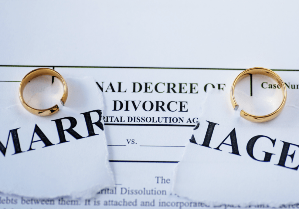 two wedding rings resting on a certificate of divorce